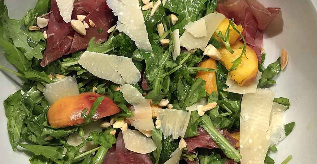 Warme Pfirsiche geben dem Rauke-Salat einen besonderen Kick.